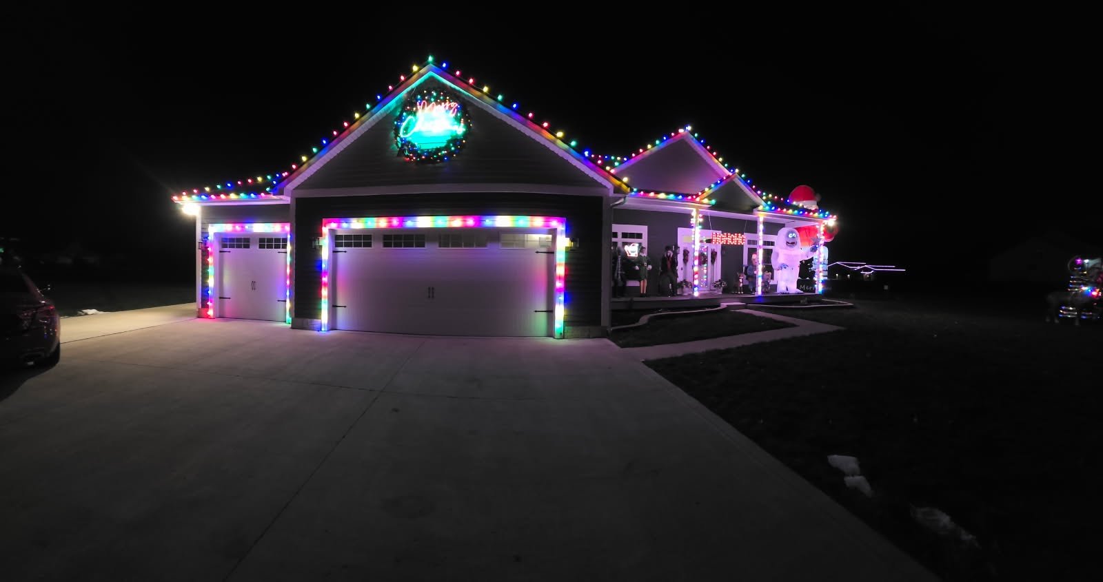 Red and warm white Christmas lights outlining a home and garage in the Winter Glow portfolio